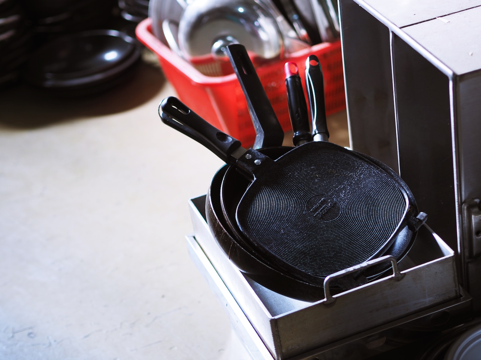 black and red handled frying pan on white table